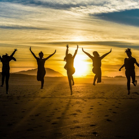  Friends at sunset on a beach in Galicia